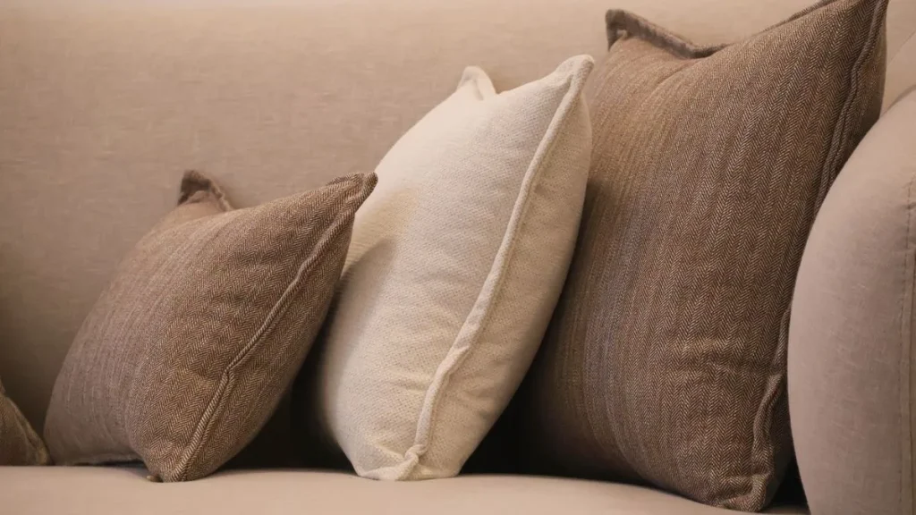 Comment faire des coussins de canapé : coussins faits main de plusieurs tailles et tissus sur un canapé beige
