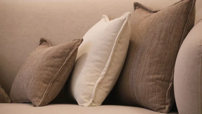 Comment faire des coussins de canapé : coussins faits main de plusieurs tailles et tissus sur un canapé beige