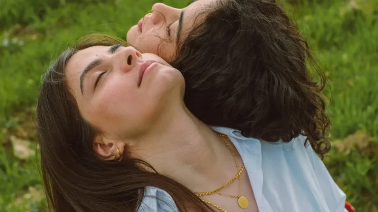 Comment faire du bien : deux amies se détendent au soleil, yeux fermés, dans l'herbe