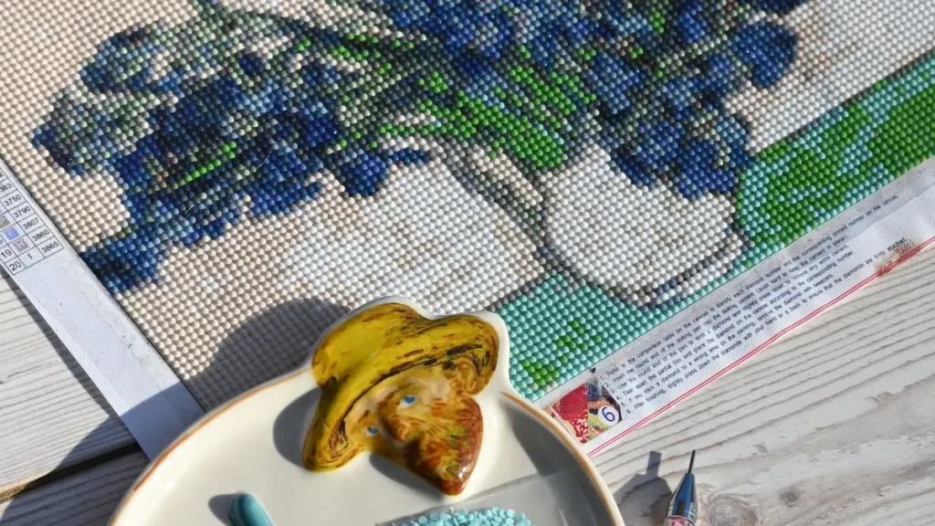 Comment faire du diamond painting : toile en cours avec la légende des symboles, le stylo applicateur et le plateau de diamants