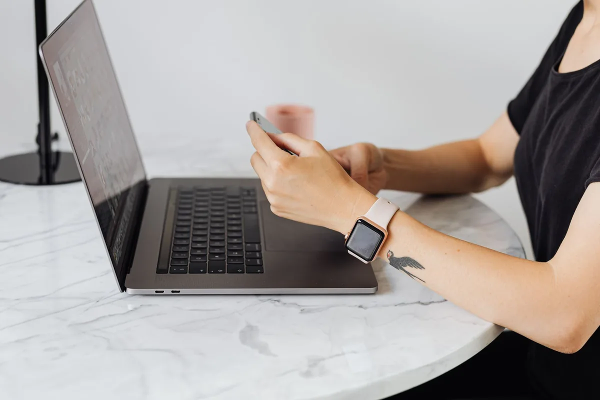 Setter qui prospecte sur son smartphone devant son ordinateur portable pour faire du setting
